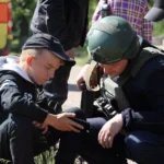 Полицейский и подросток смотрят в смартфон