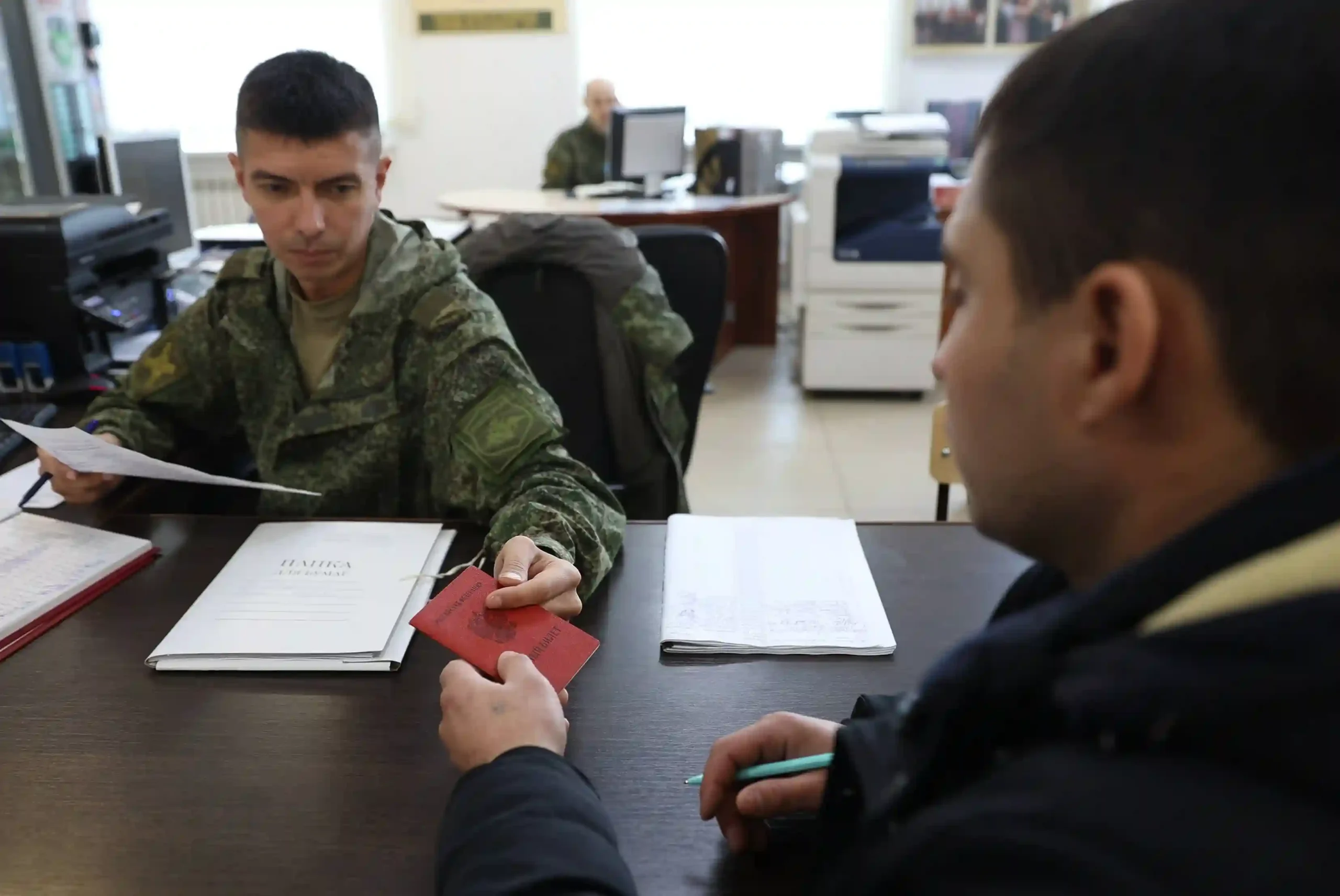 A volunteer submits his documents for military service
