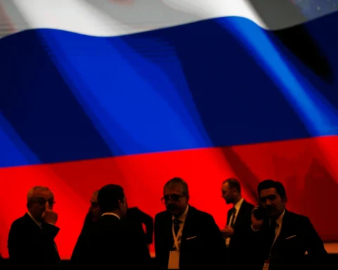 Backdropped by Russia s flag officials wait