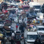 Перемещенные палестинцы ждут на дороге