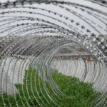 Колючая проволока в форме спирали и противотанковые сваи