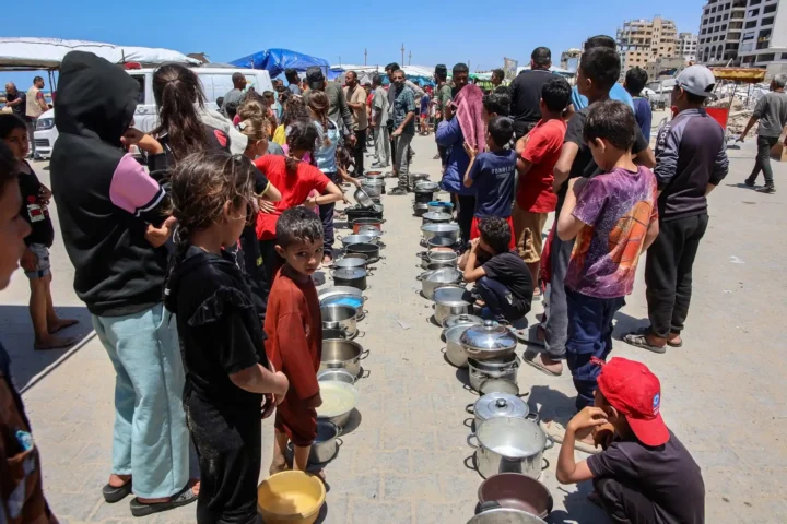 Palestinians line up to receive a hot meal