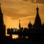 Люди смотрят и фотографируют закат