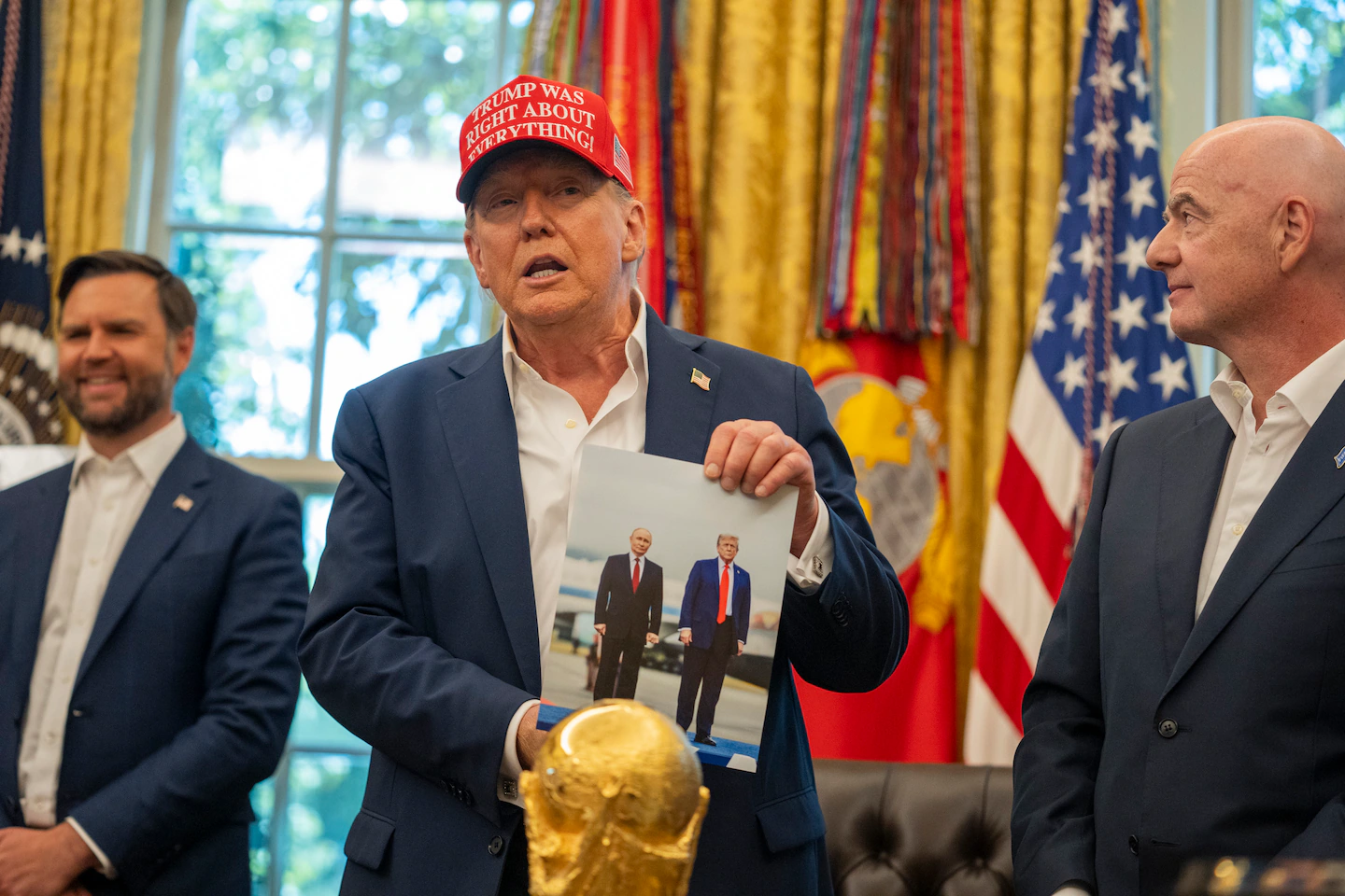 Президент Дональд Трамп держит фотографию