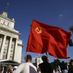 Демонстрант несёт советский флаг