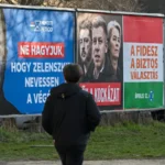 Пешеход проходит мимо рекламных щитов